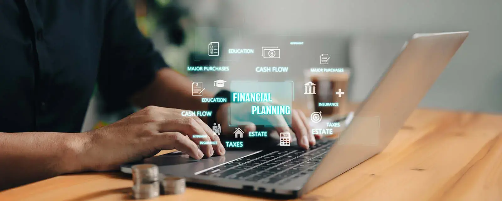 Hands on a laptop keyboard with financial related words floating above