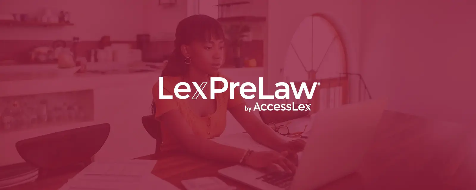 An African American female student sitting at a computer researching the LexPreLaw pathway program. 