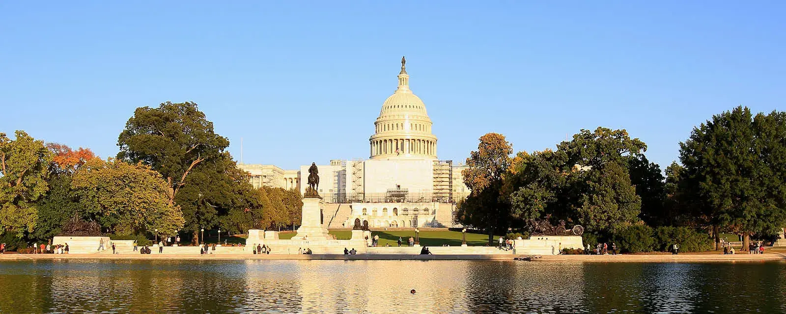 U.S. Capitol Building on a summer day with trees and a blue sky.