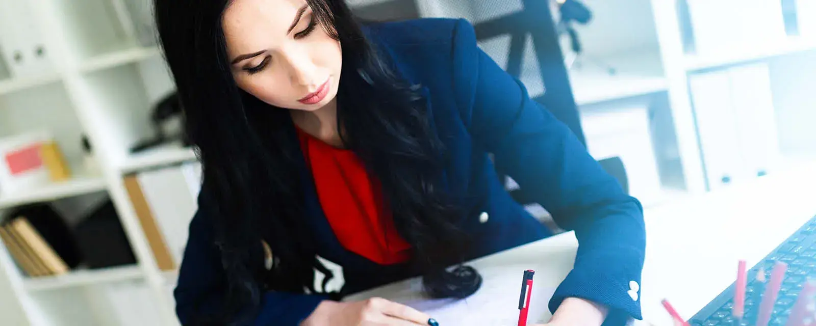 Portrait of a young girl in a suit. Beautiful girl is working in the office.