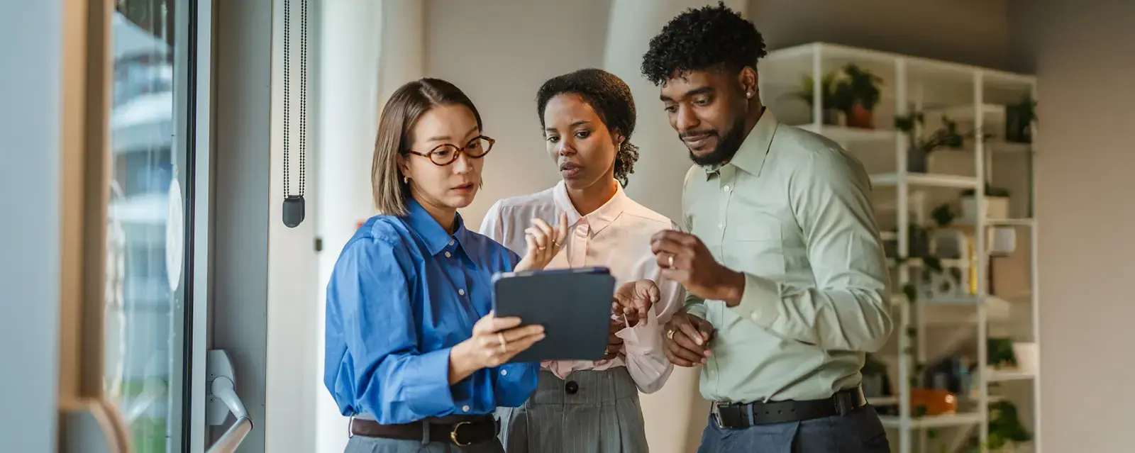 Three people looking at a tablet