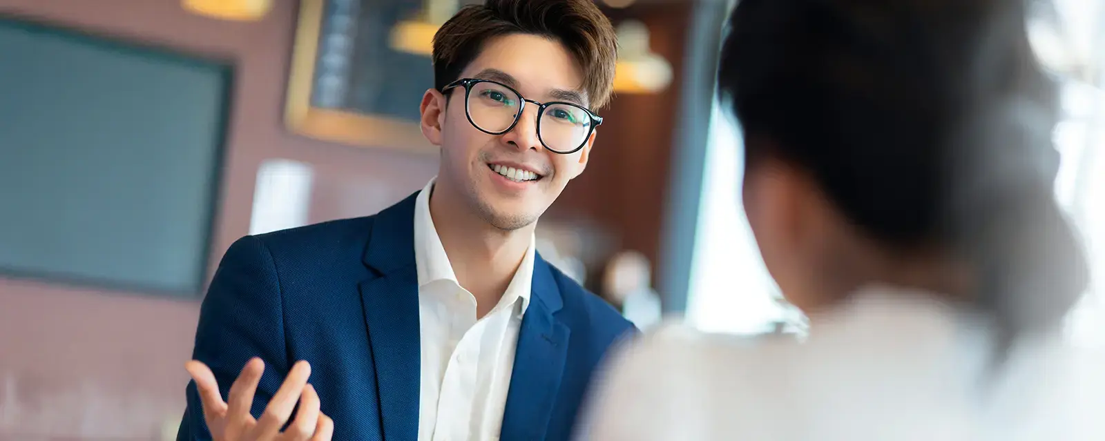 Young male lawyer consulting with female business partner in a cafe setting.