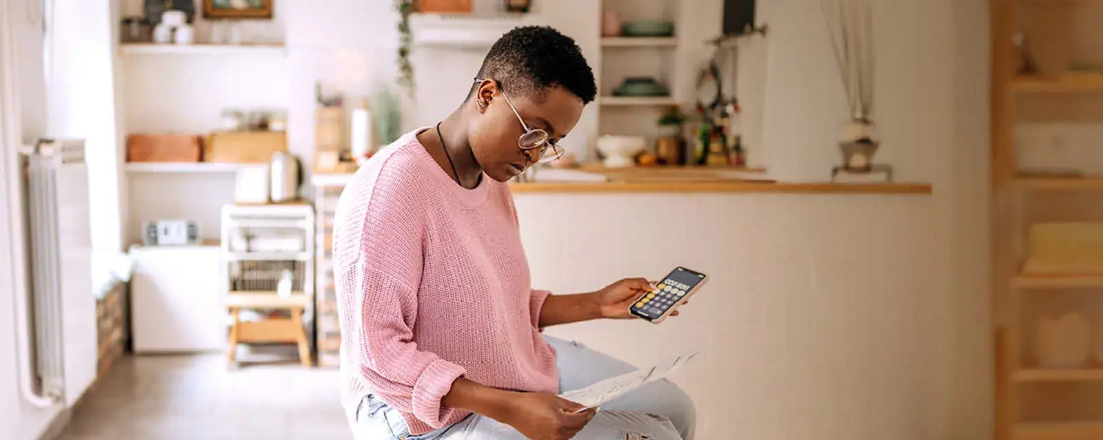 Young women holding a calculator and looking down at papers