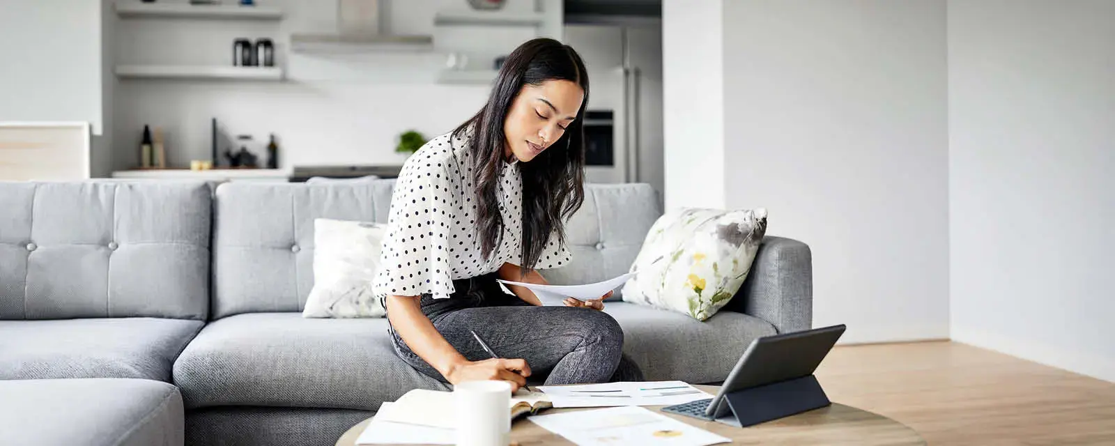 Woman analyzing documents while sitting at home.
