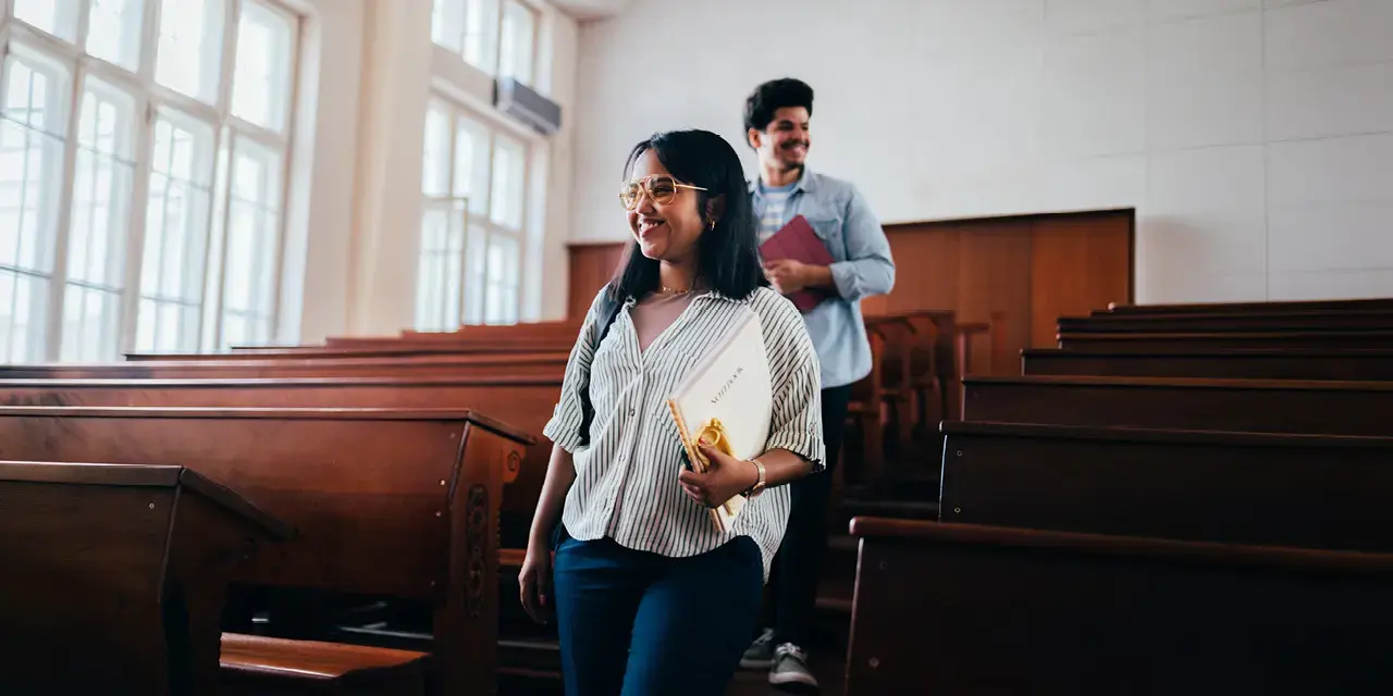 Student walking down stairs in a lecture hall.