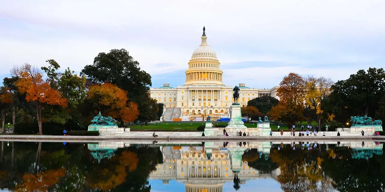 U.S. Capitol Building on an autumn day with trees showing colorful leaves.