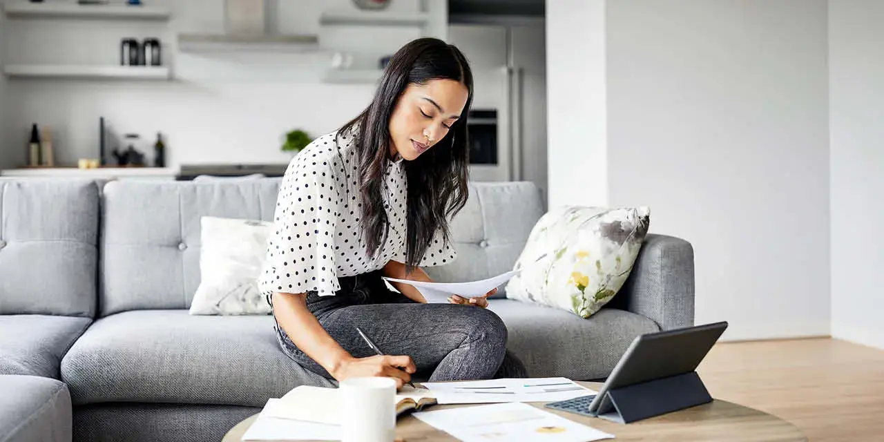 Woman analyzing documents while sitting at home.