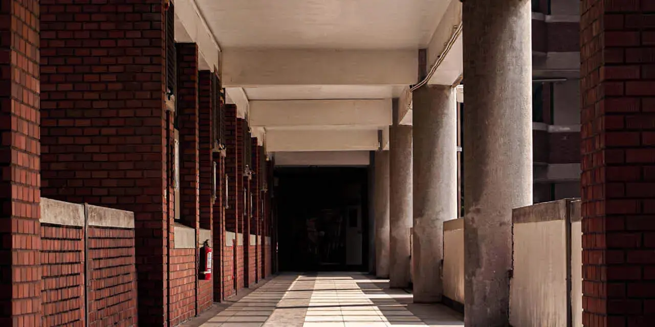 An empty college campus walkway depicting the impact of graduate and professional student loan cuts.