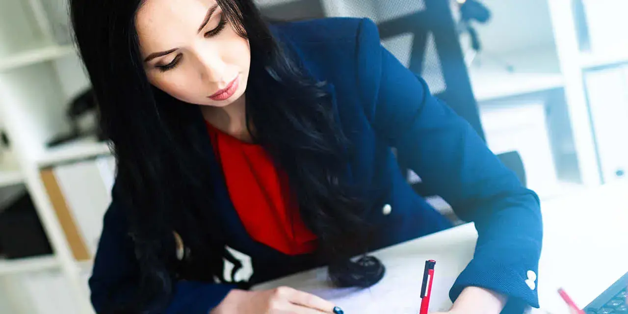 Portrait of a young girl in a suit. Beautiful girl is working in the office.