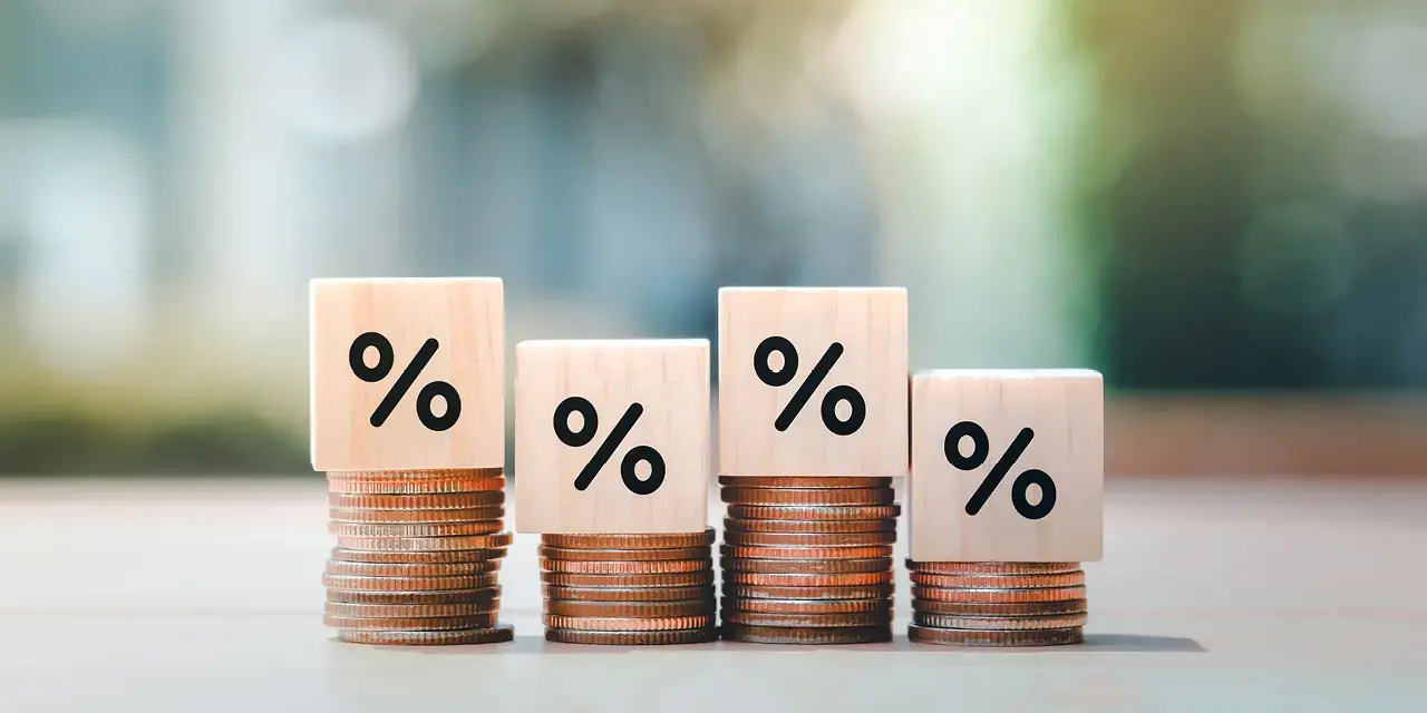 Displayed interest rates and mortgage rates. Wooden block with percentage sign on many level of stack of coin. Illustrating financial growth, interest rate increase, inflation, sale price and tax rise concepts.