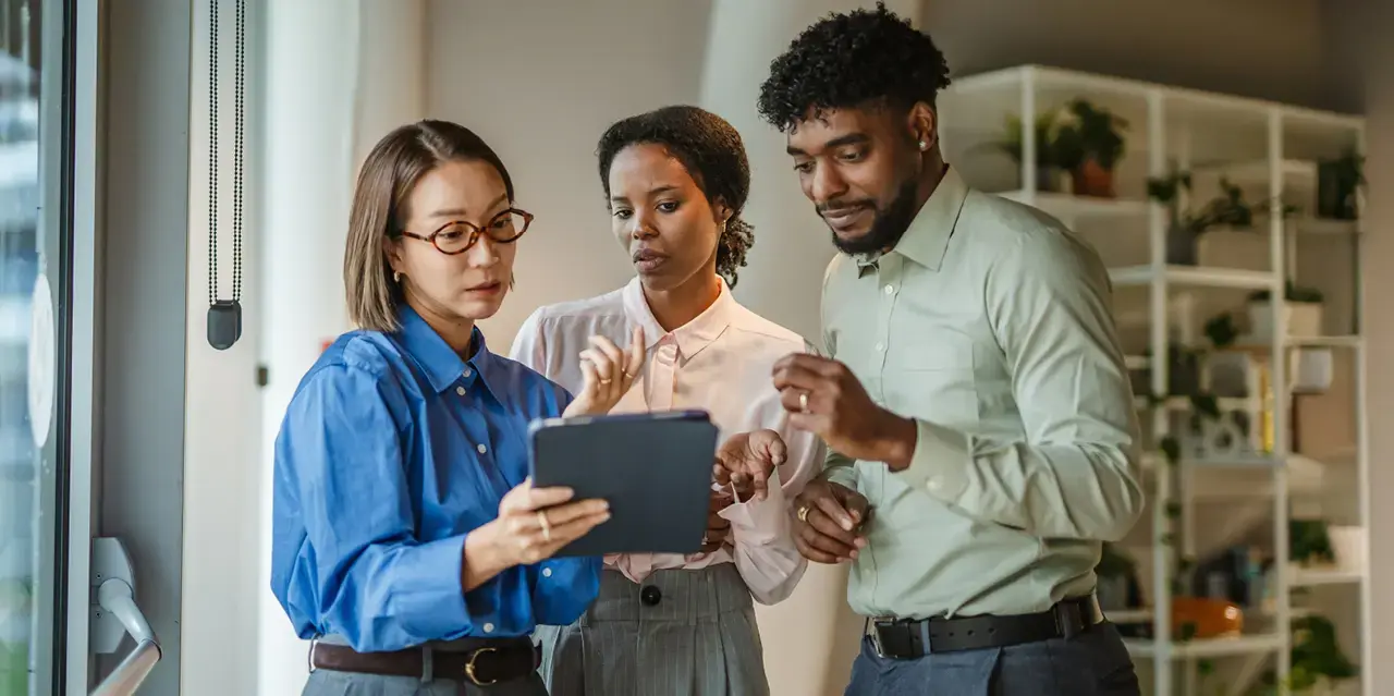 Three people looking at a tablet