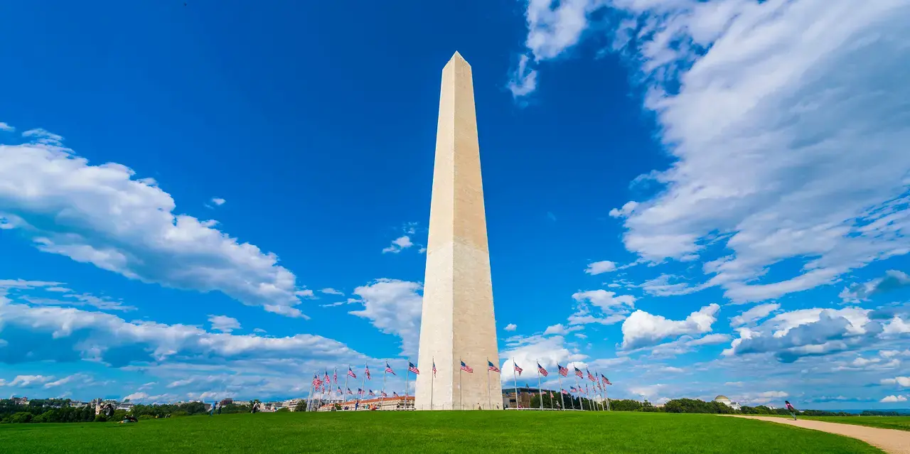 Washington monument on sunny day with blue sky background. 