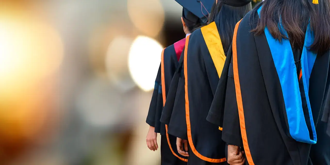 View showing the back of college graduates wearing graduation robes