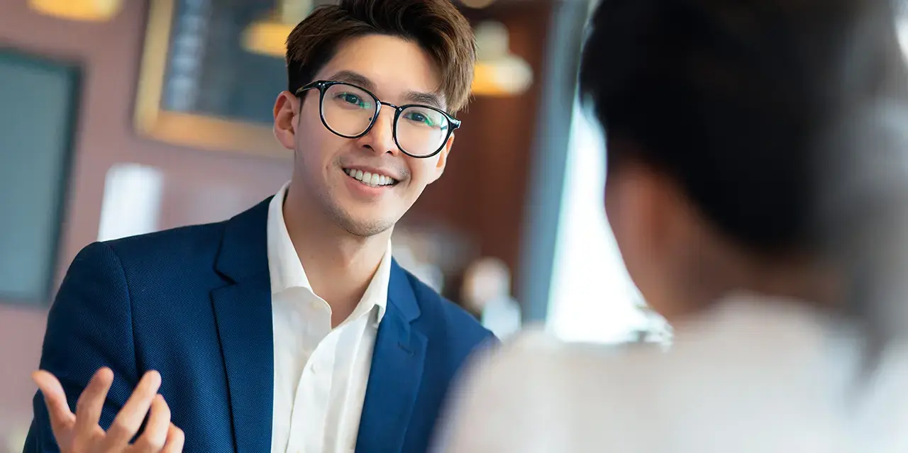 Young male lawyer consulting with female business partner in a cafe setting.