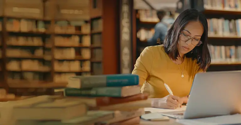 Young lady using a laptop to do research on the internet.  