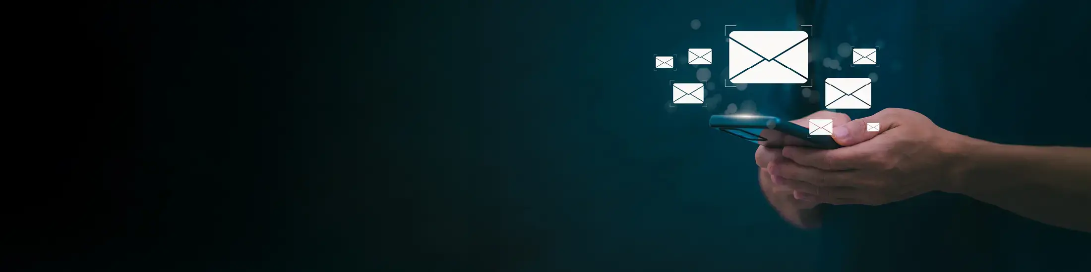 Hands holding a phone with email icons surrounding the phone. 