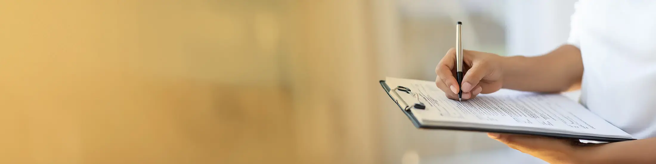 A person holding a clipboard and a pen in an office.