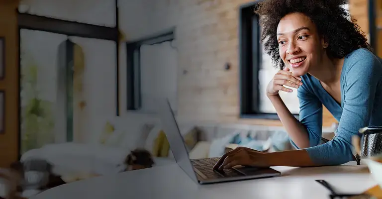Happy black couple surfing the internet on a computer in the kitchen 