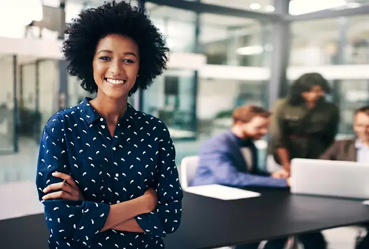 Young professional women with arms crossed smiles at the camera