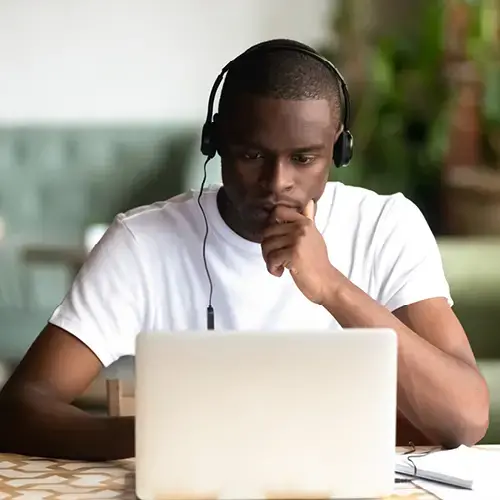 Man wearing headphones looking at a laptop