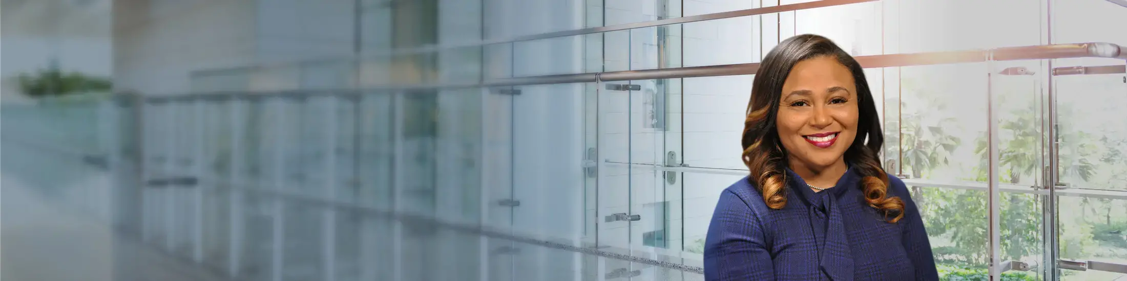 A law school administrator with a dark shirt in front of a wall of windows