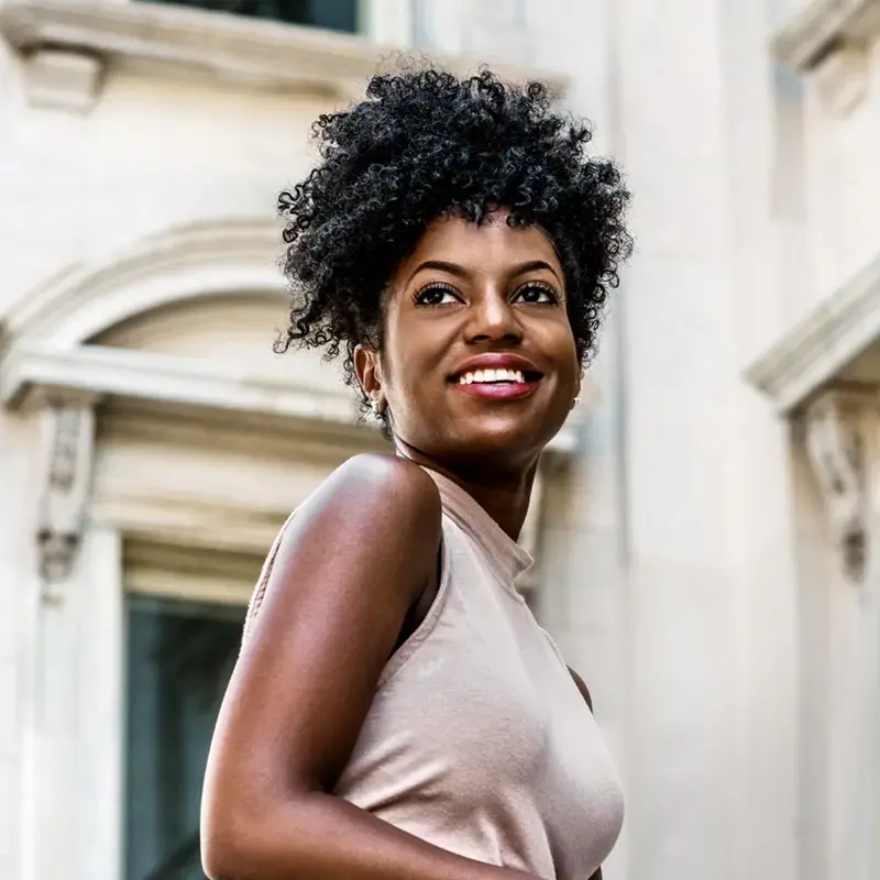 Close-up of an African American Woman smiling and looking to her right.