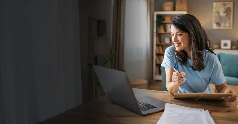 A smiling woman reviews private loan options for law school on her computer screen. 