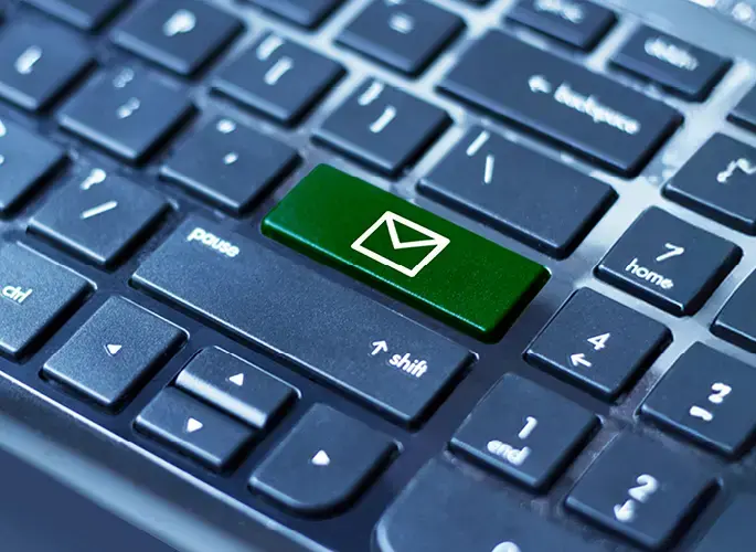 A closeup of a laptop keyboard. The Enter key icon has been replaced with an envelope icon.