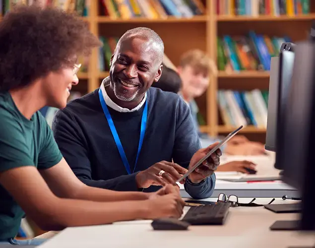 Law school faculty member pointing to a tablet as a student looks on.