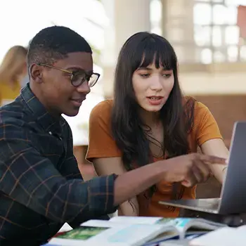 Students working at a laptop.