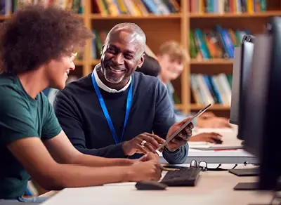 Law school faculty member pointing to a tablet as a student looks on.