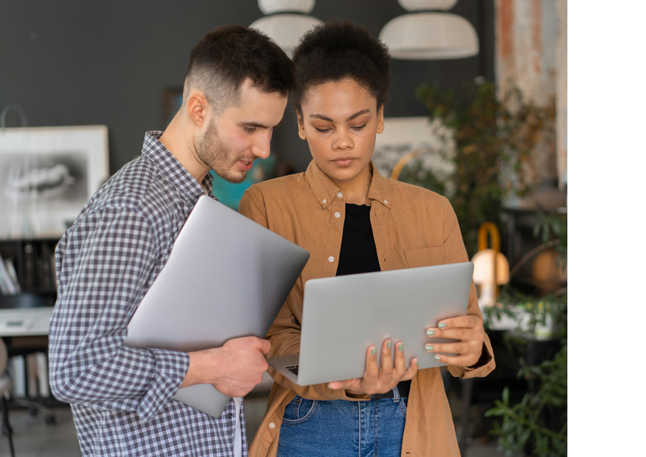 male and female students holding laptops