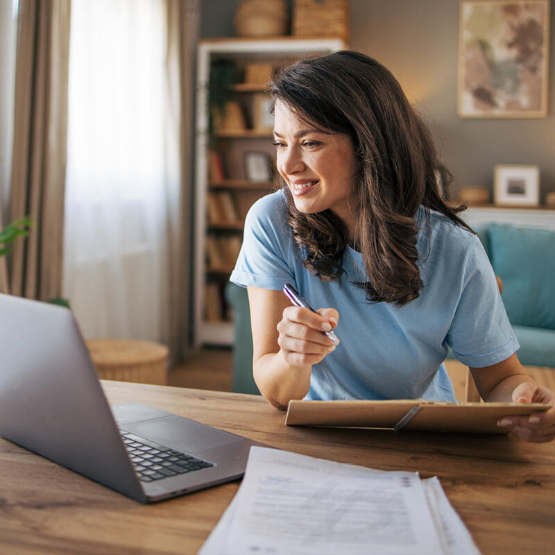  A smiling woman reviews private loan options for law school on her computer screen. 